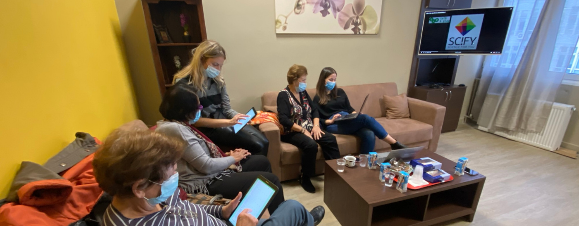 a group of women sitting together each using a tablet or mobile device to use the talk and play app.