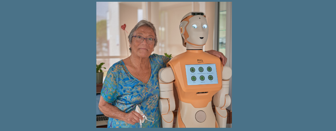 Elderly woman hugging a PAL robot.