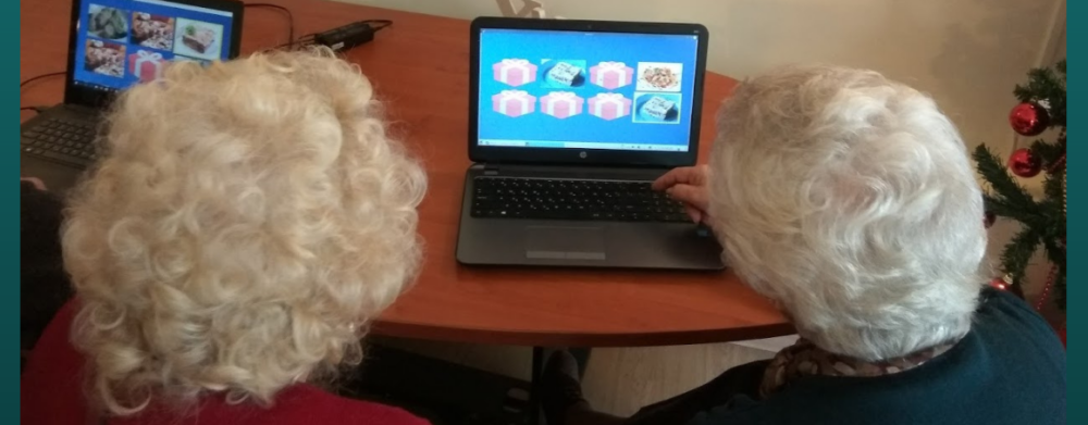 Photo of two elderly women playing a memory game using a laptop.