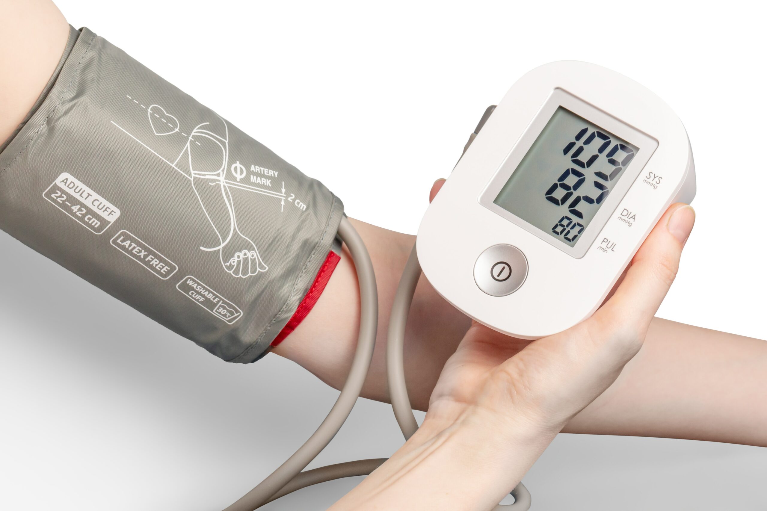 Photograph of a person with a cuff on their arm attached to a blood pressure monitor
