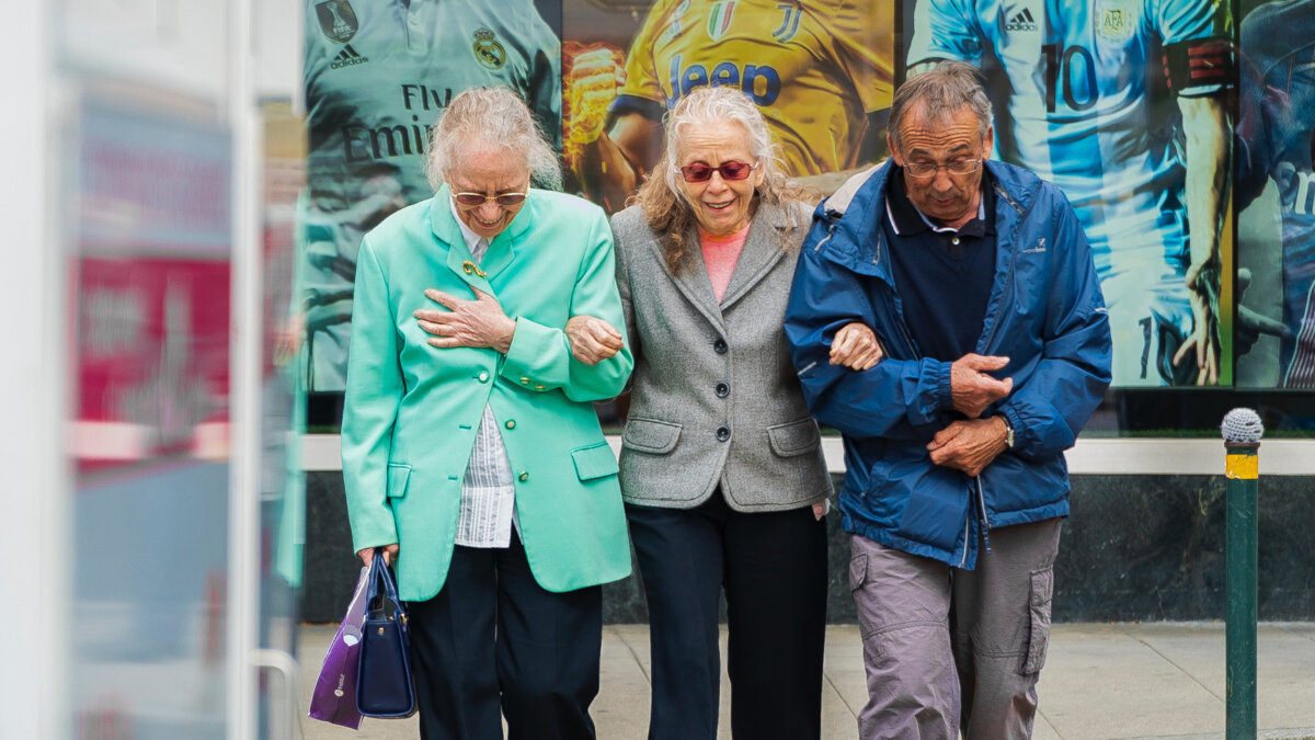 Image of three older adults crossing the street.
